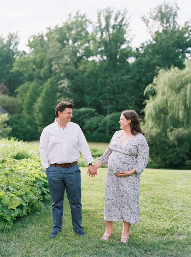 Maternity session at Brookside Gardens — expecting mother walking hand in hand with her husband, captured by luxury maternity & newborn photographer Washington DC area.